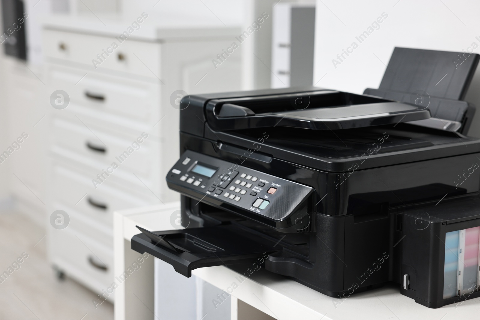 Photo of Modern printer on white table in office. Space for text