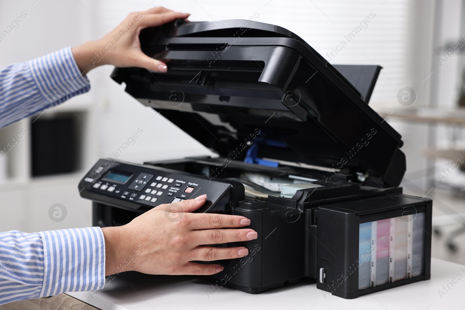 Photo of Woman using modern printer at workplace indoors, closeup