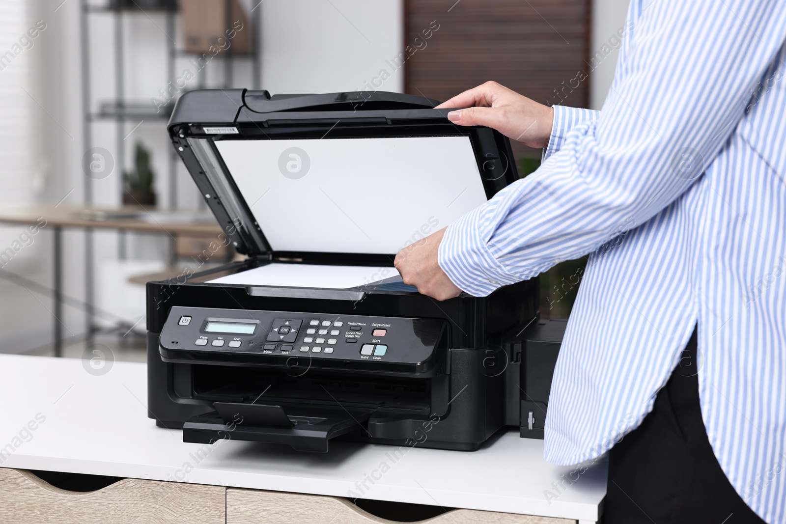 Photo of Woman using modern printer at workplace indoors, closeup