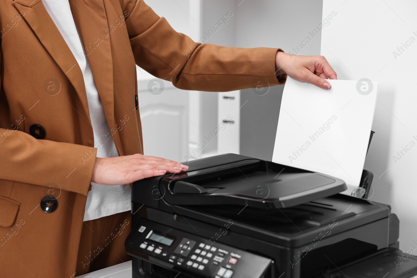 Photo of Woman using modern printer at workplace indoors, closeup