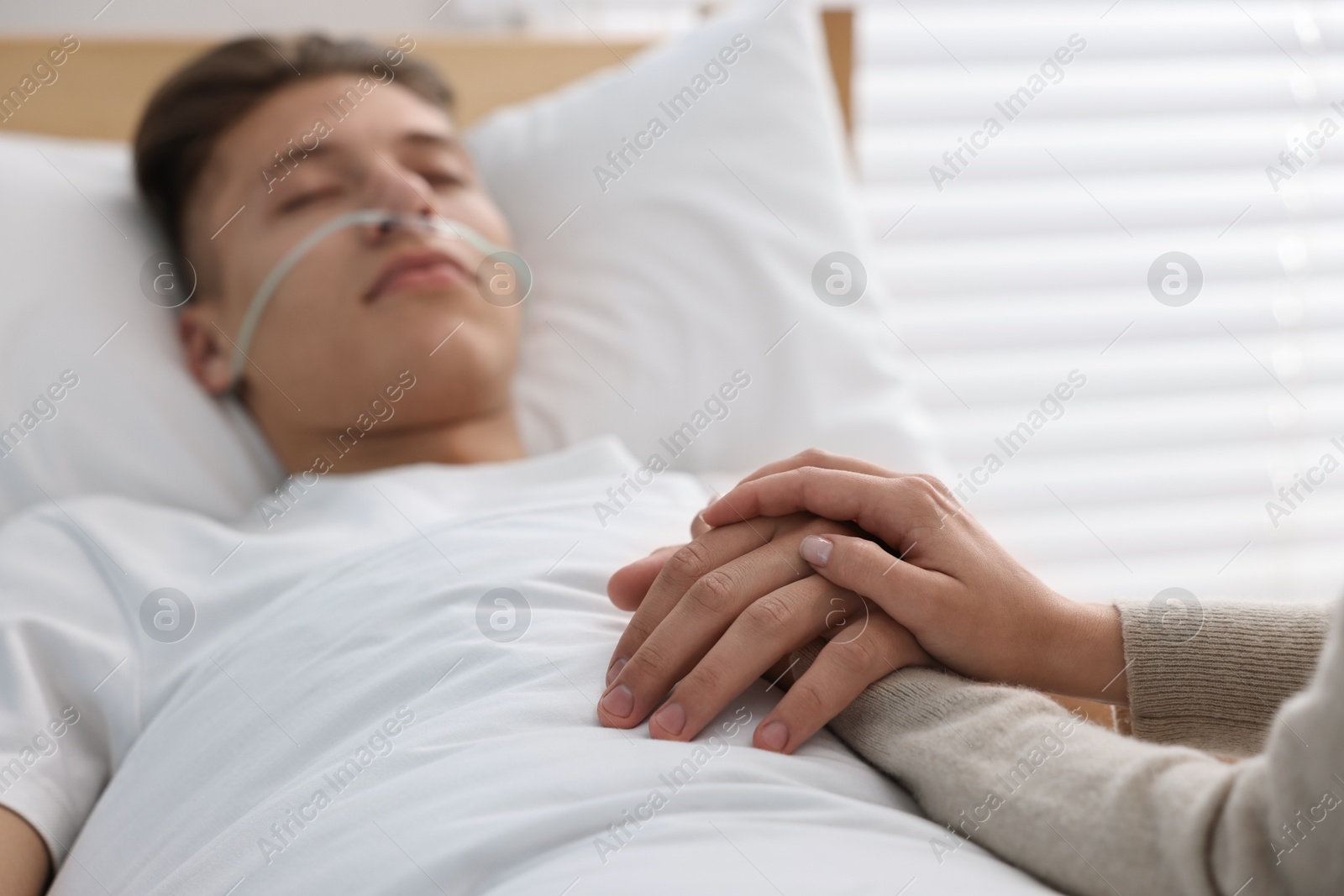 Photo of Coma patient. Woman near her husband in hospital, selective focus