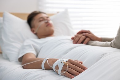 Photo of Coma patient. Woman near her husband in hospital, selective focus