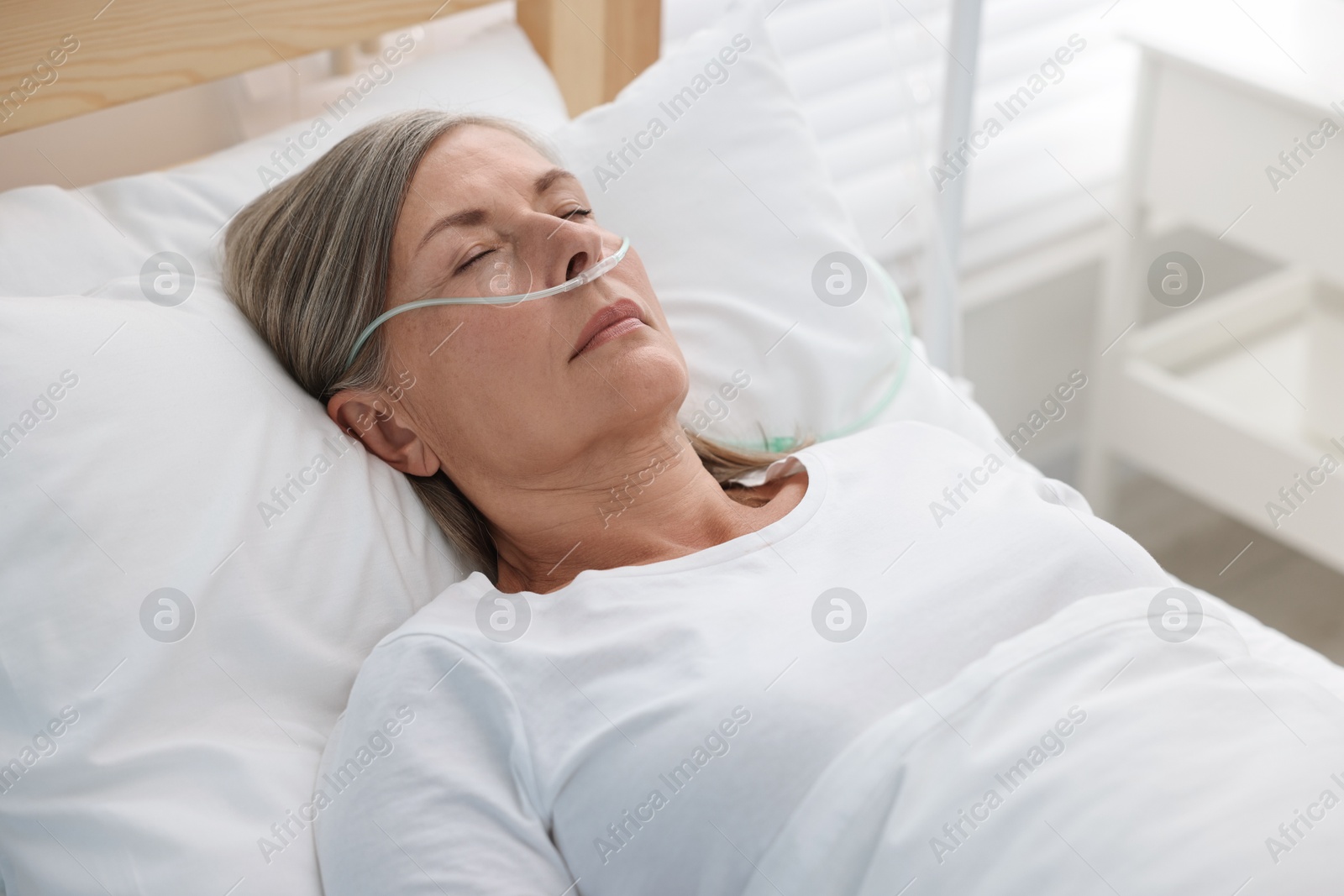 Photo of Coma patient. Mature woman sleeping in hospital bed