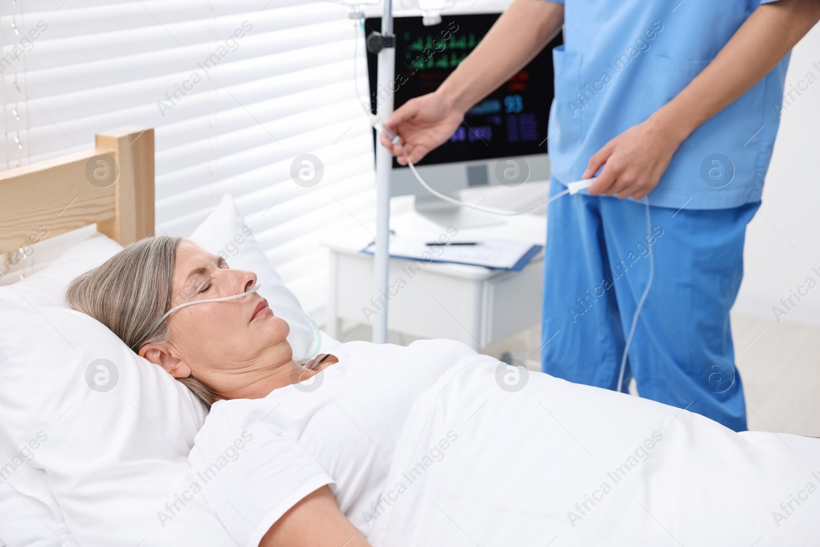 Photo of Coma patient. Doctor near unconscious mature woman in hospital, closeup