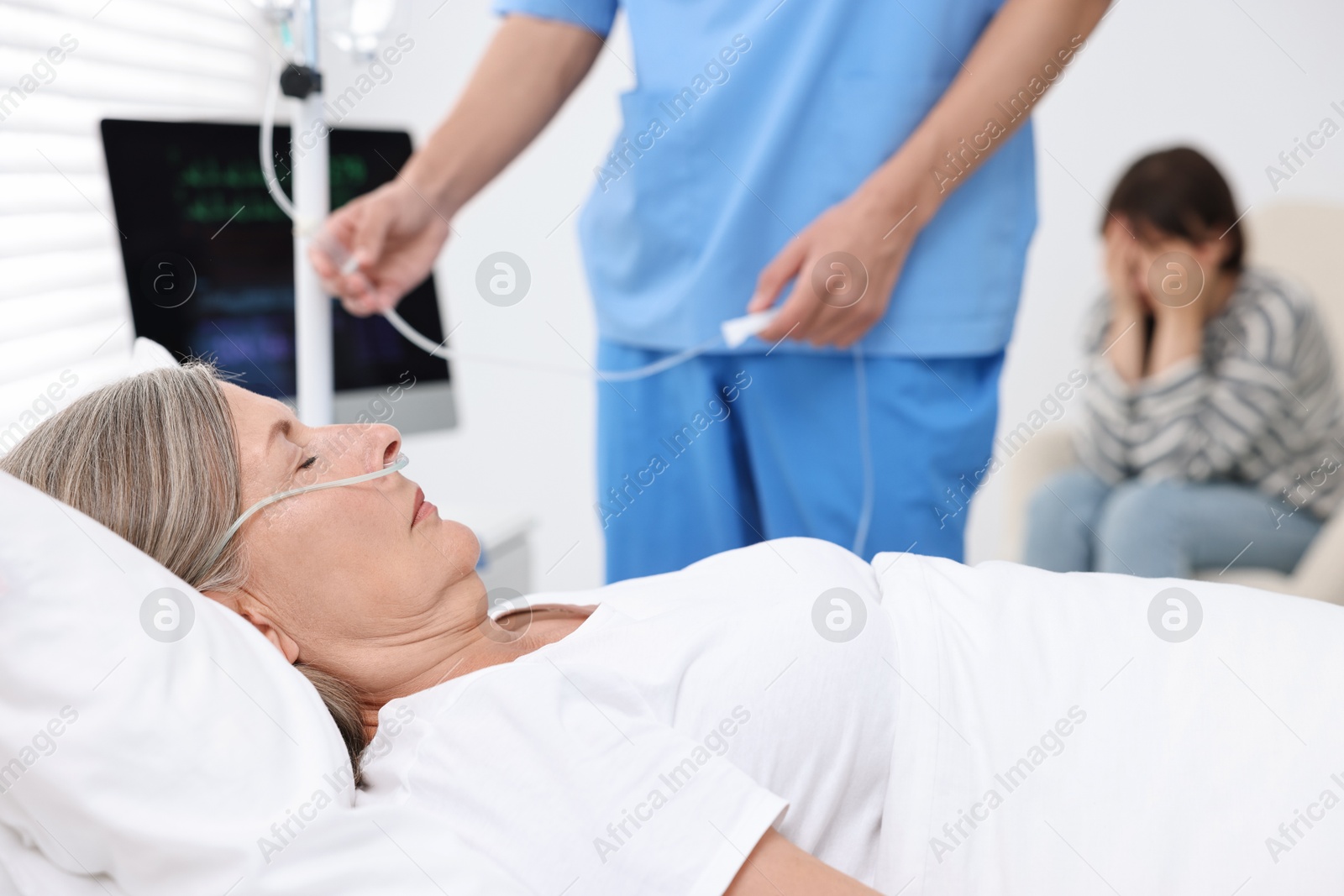 Photo of Coma patient. Doctor near unconscious mature woman in hospital