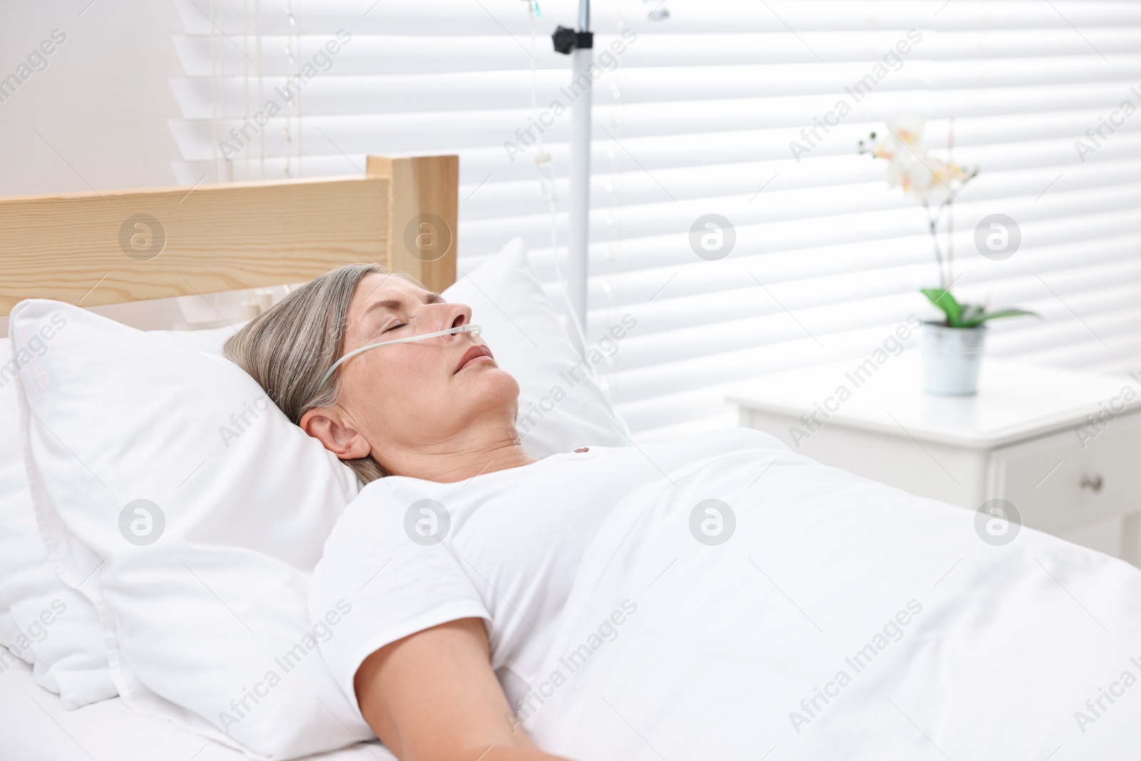 Photo of Coma patient. Mature woman sleeping in hospital bed