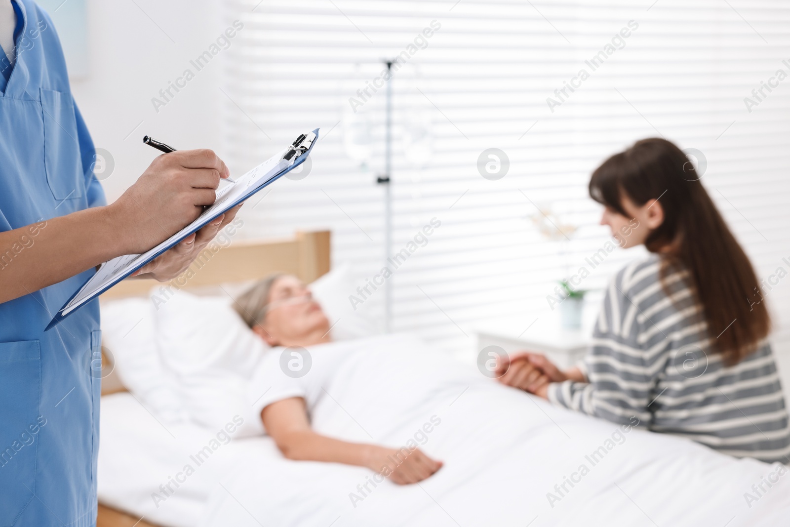 Photo of Coma patient. Doctor near unconscious mature woman in hospital, closeup