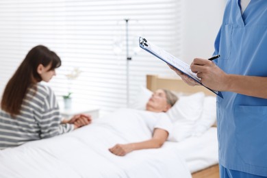 Photo of Coma patient. Doctor near unconscious mature woman in hospital, closeup