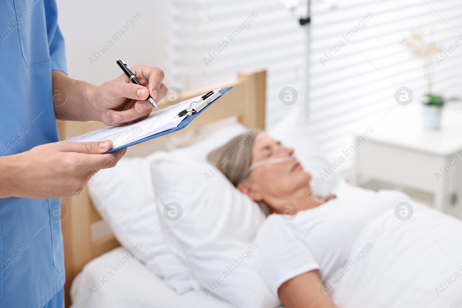 Photo of Coma patient. Doctor near unconscious mature woman in hospital, closeup