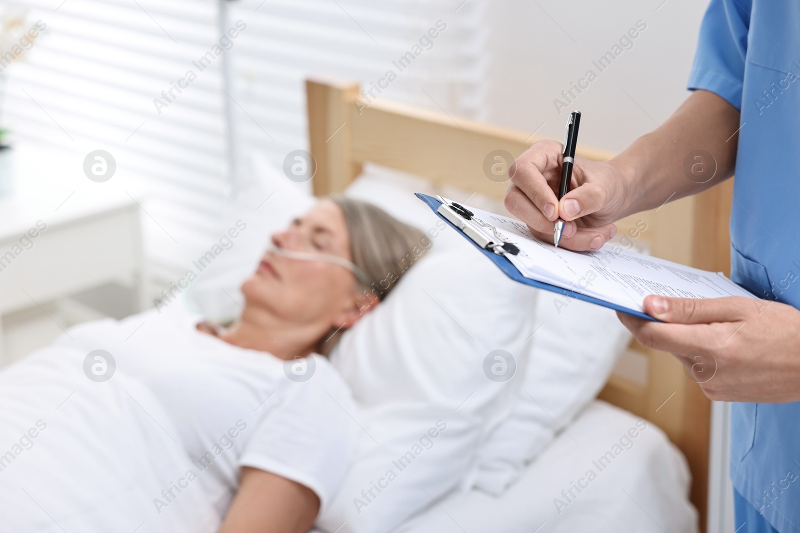 Photo of Coma patient. Doctor near unconscious mature woman in hospital, closeup