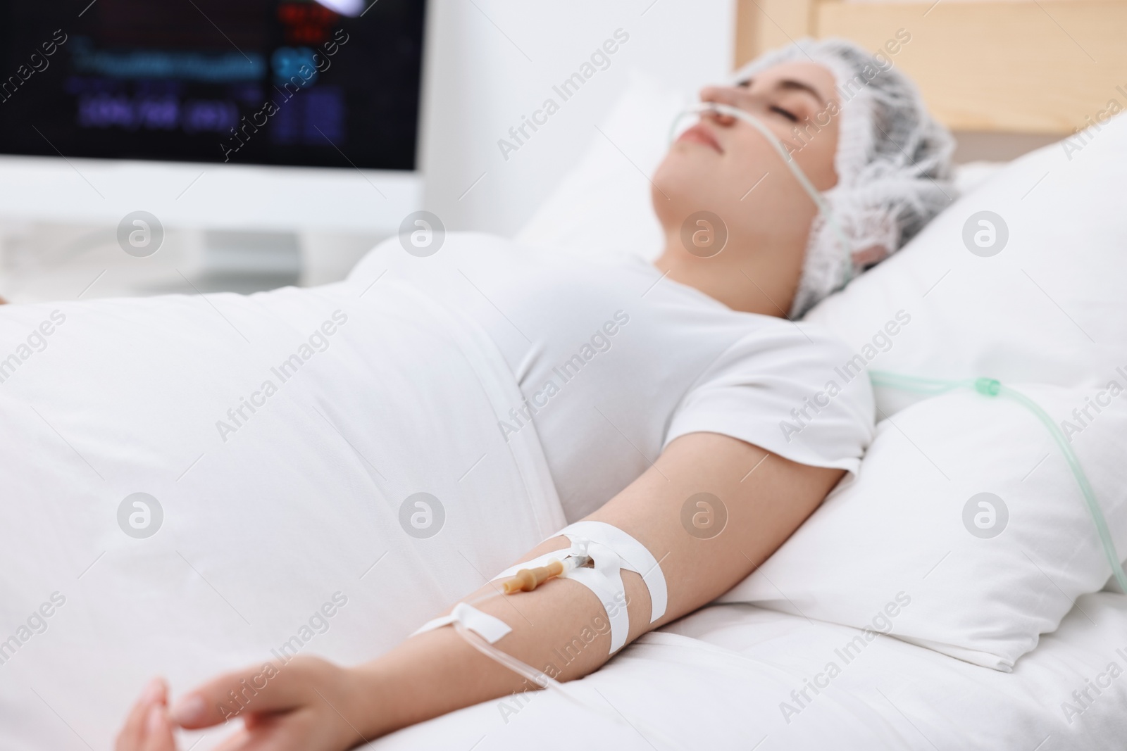 Photo of Coma patient. Woman with intravenous drip in hospital bed, selective focus