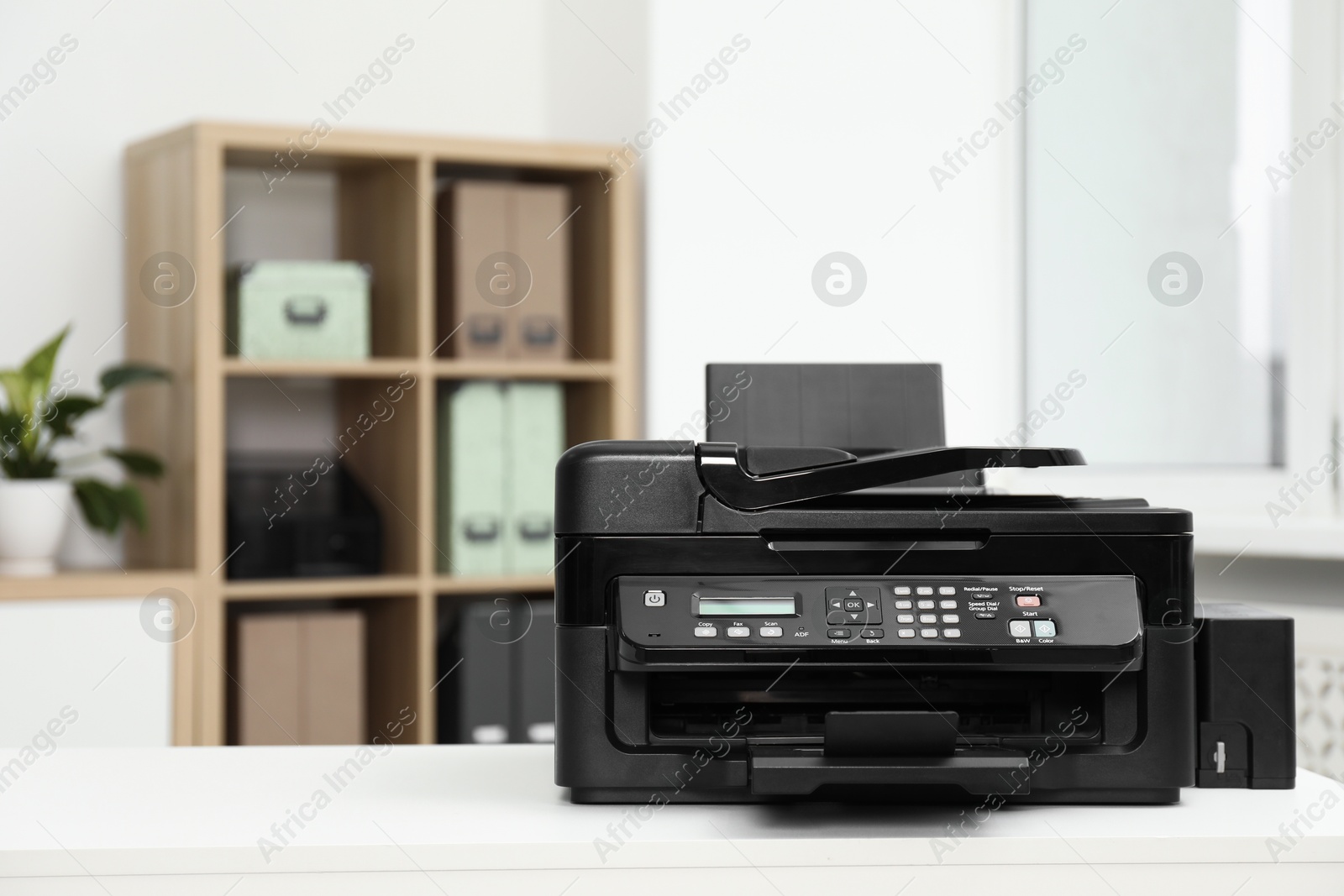 Photo of Modern printer on white table in office