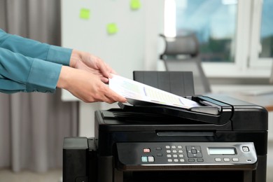 Photo of Woman using modern printer at workplace indoors, closeup