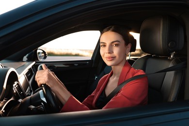 Photo of Beautiful young woman with seatbelt driving car, view from outside