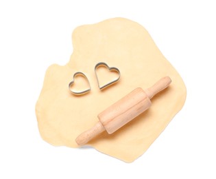 Raw dough, wooden rolling pin and cookie cutters isolated on white, top view