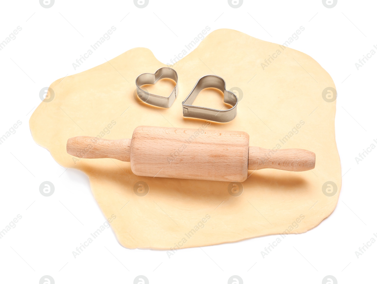 Photo of Raw dough, wooden rolling pin and cookie cutters isolated on white