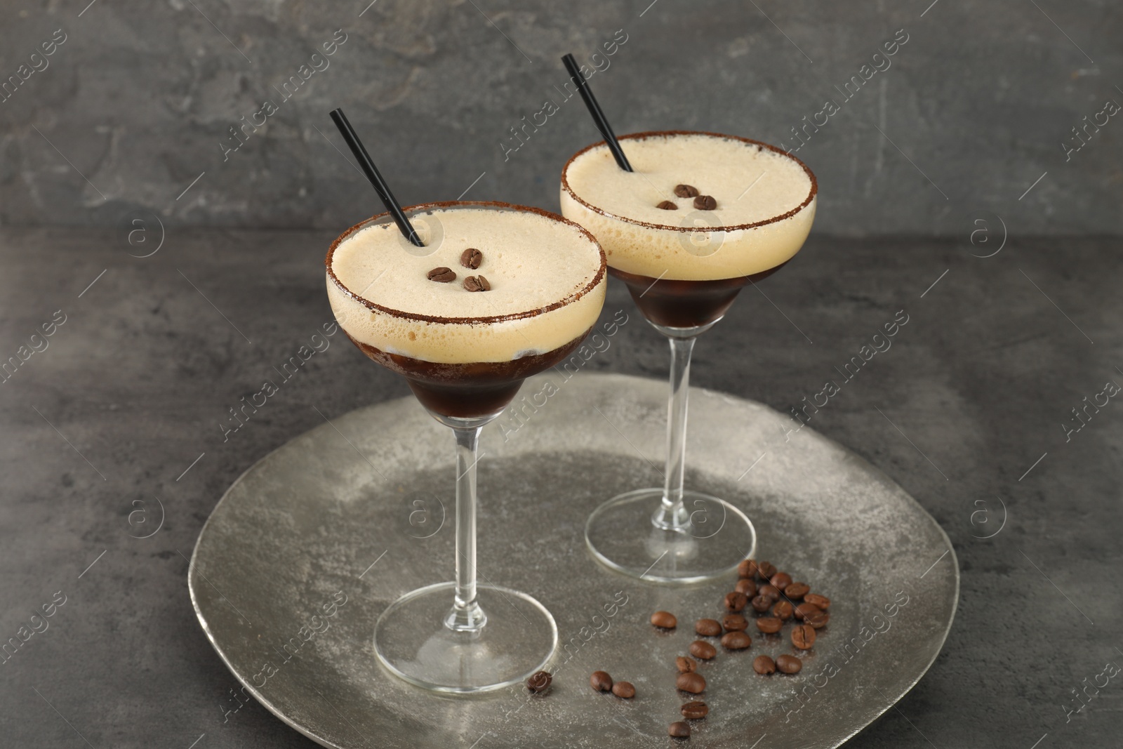 Photo of Glasses of fresh coffee cocktail on gray textured table