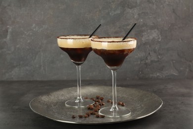 Photo of Glasses of fresh coffee cocktail on gray textured table