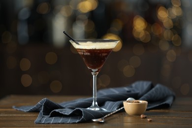 Photo of Refreshing cocktail, spoon and coffee beans on wooden table