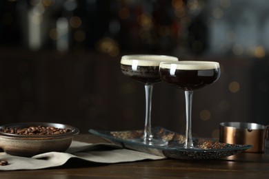 Refreshing cocktails and coffee beans on wooden table