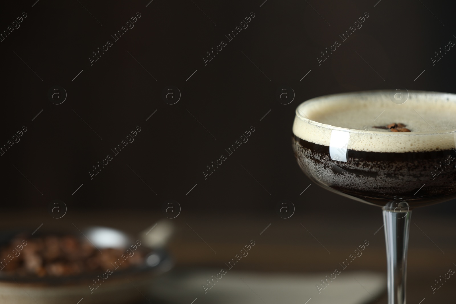 Photo of Refreshing cocktail in glass on blurred background, closeup. Space for text