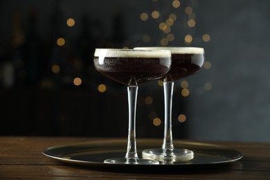 Refreshing cocktails in glasses on wooden table