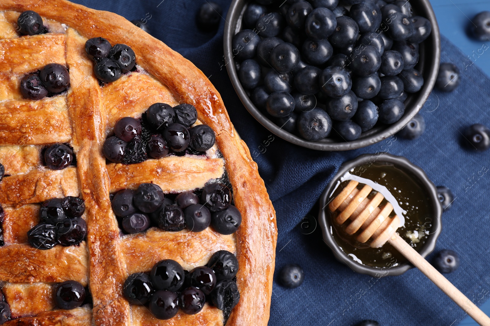 Photo of Tasty homemade pie with blueberries served on blue table, flat lay