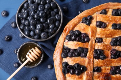 Photo of Tasty homemade pie with blueberries served on blue table, flat lay