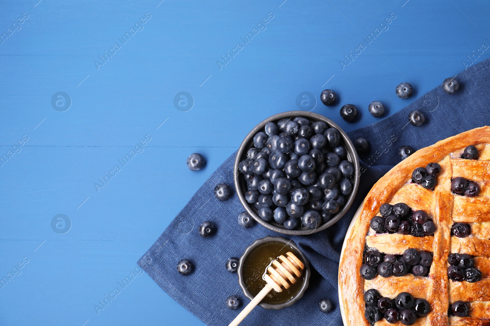 Photo of Tasty homemade pie with blueberries served on blue table, flat lay. Space for text