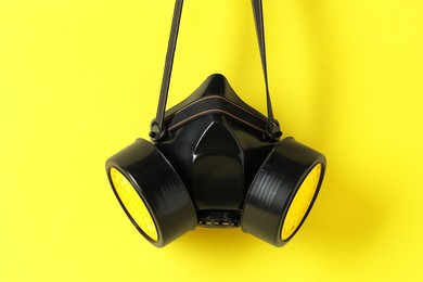 One respirator mask on yellow background. Safety equipment