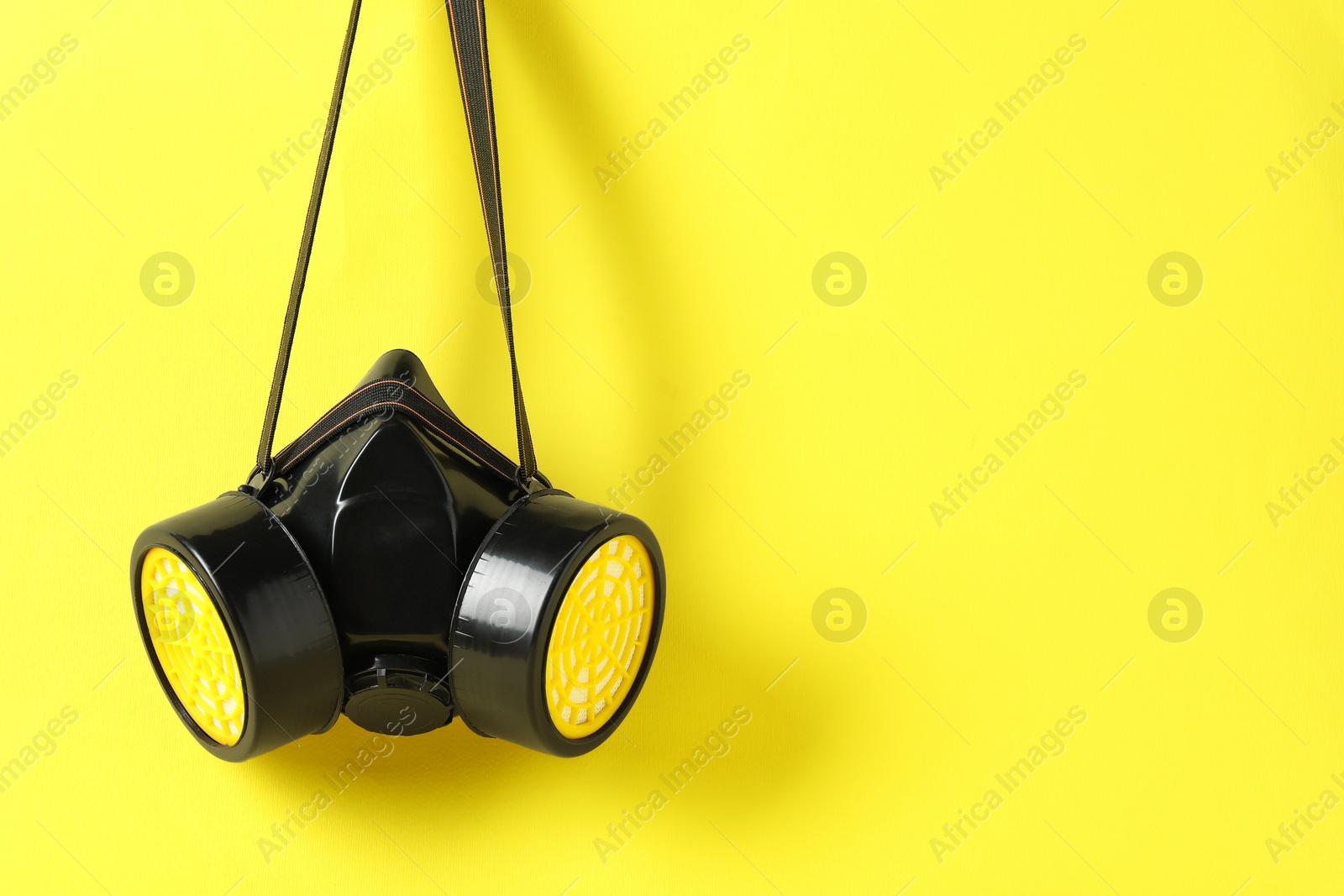 Photo of One respirator mask on yellow background. Space for text