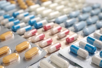 Photo of Antibiotic pills in blisters as background, closeup