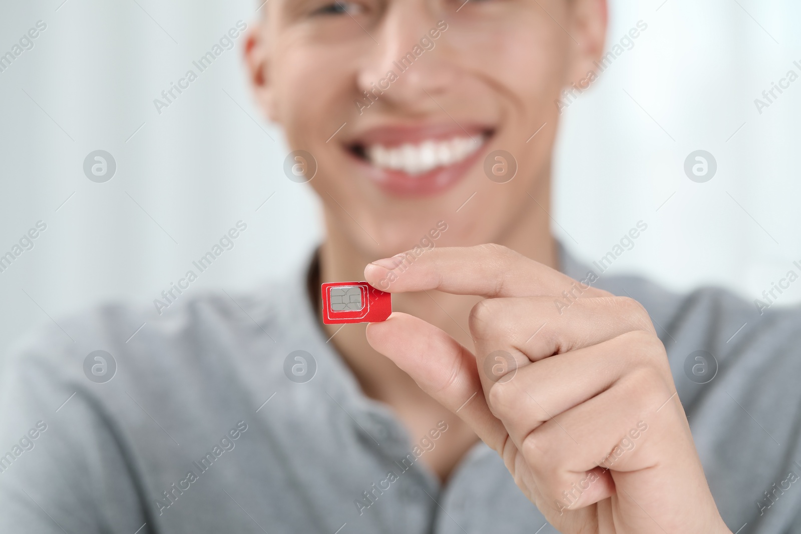 Photo of Man with SIM card at home, closeup