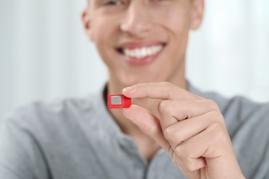 Photo of Man with SIM card at home, closeup