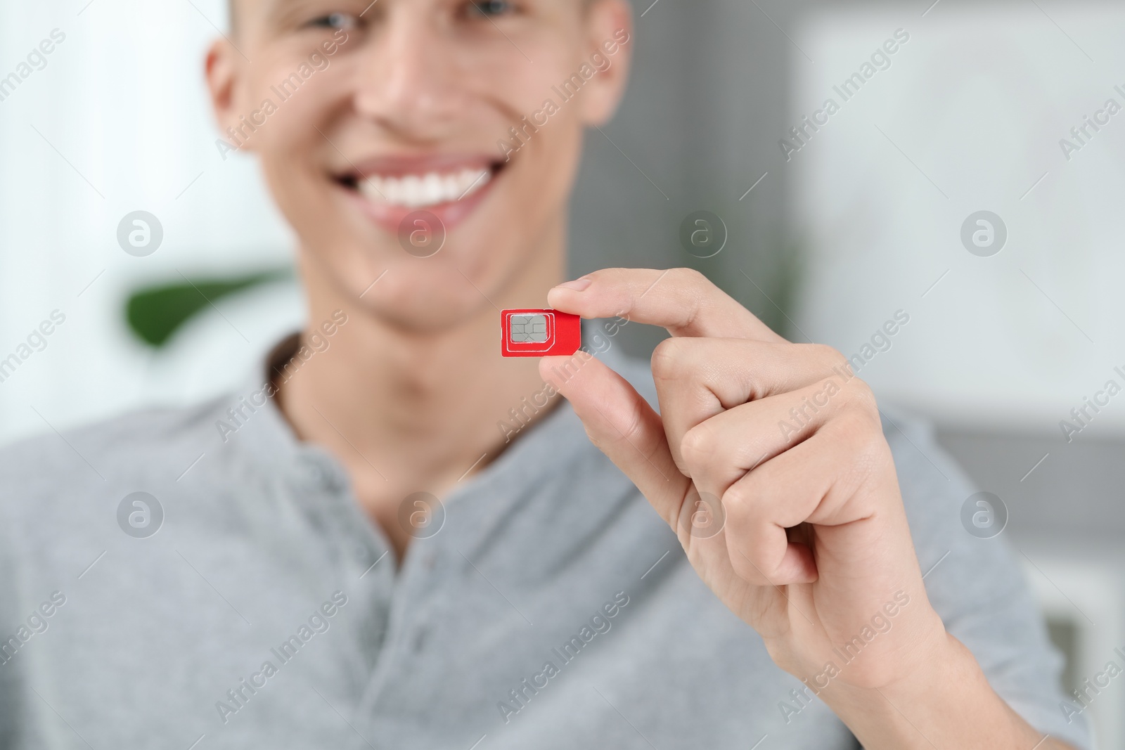 Photo of Man with SIM card at home, closeup