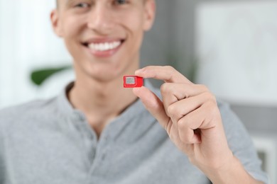 Man with SIM card at home, closeup