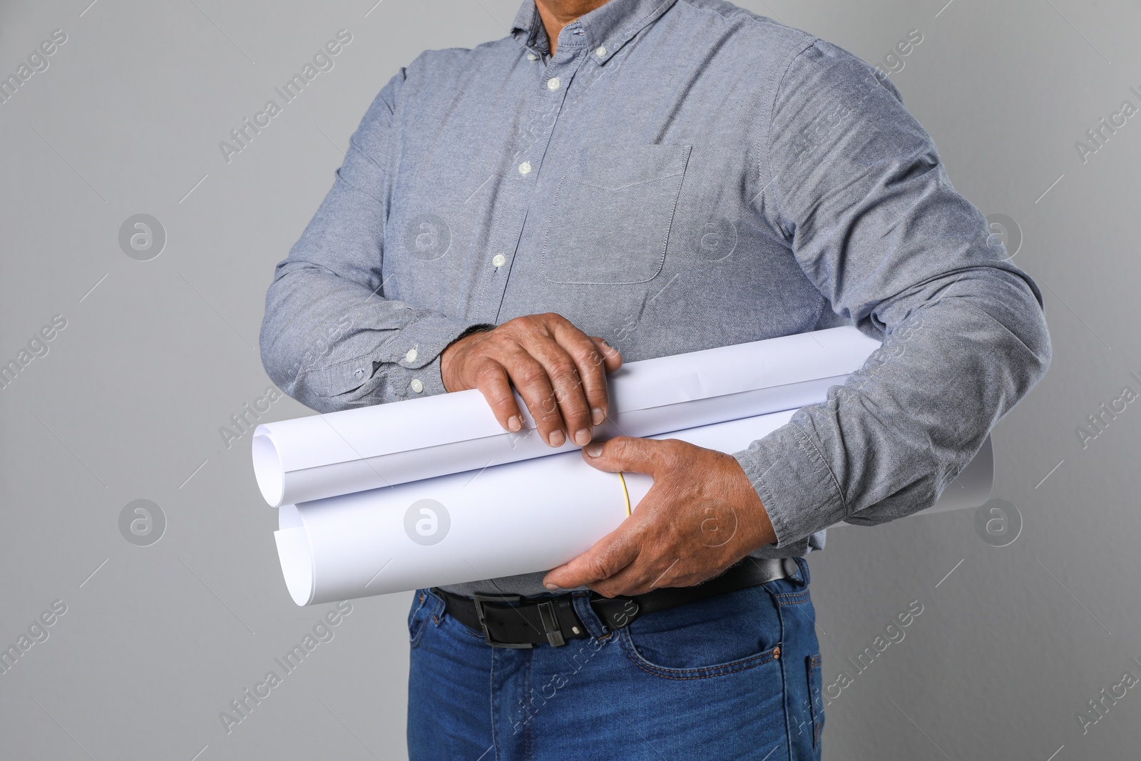 Photo of Engineer with drafts on grey background, closeup