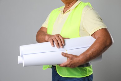 Photo of Engineer with drafts on grey background, closeup