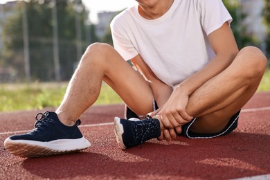 Photo of Sportsman with leg injury at stadium, closeup