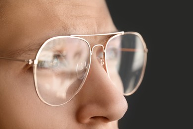 Photo of Vision correction. Man wearing glasses on grey background, closeup