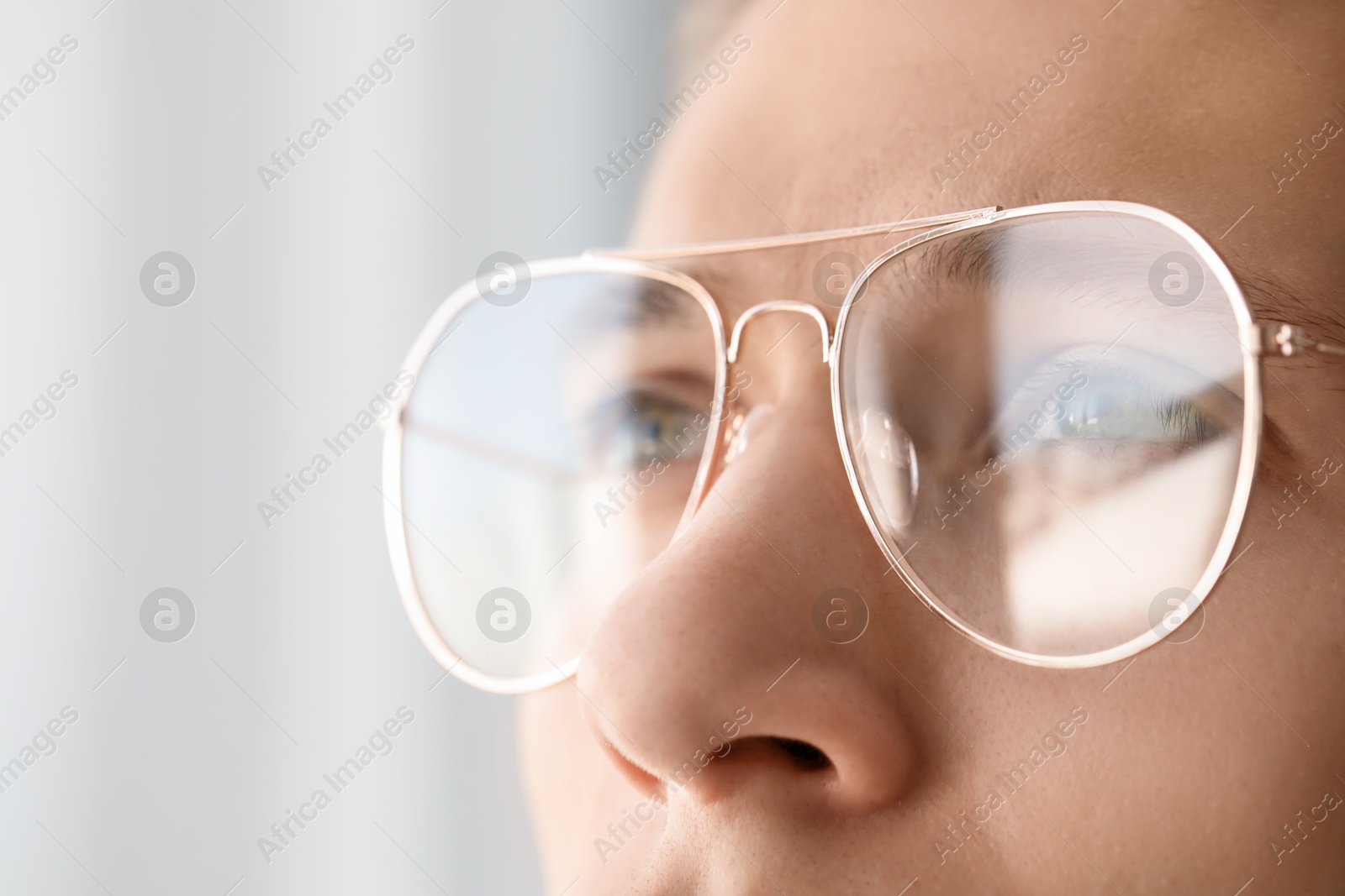 Photo of Vision correction. Man wearing glasses on blurred background, closeup