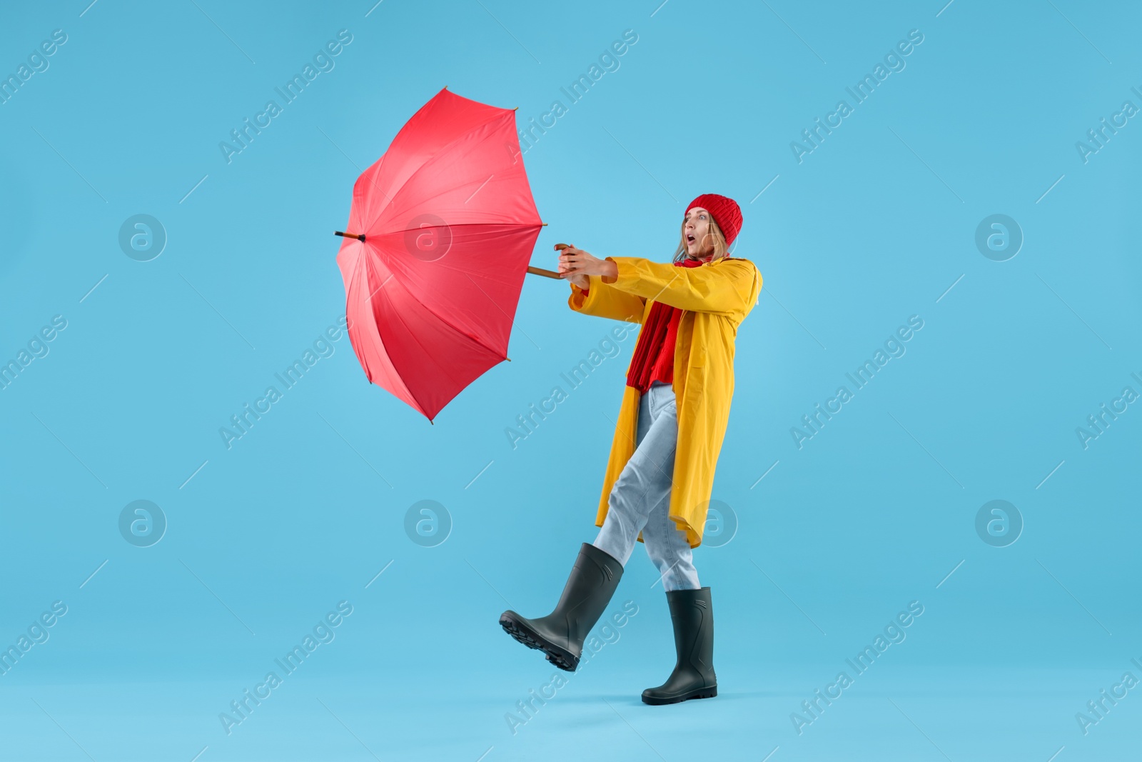 Photo of Woman with red umbrella on light blue background