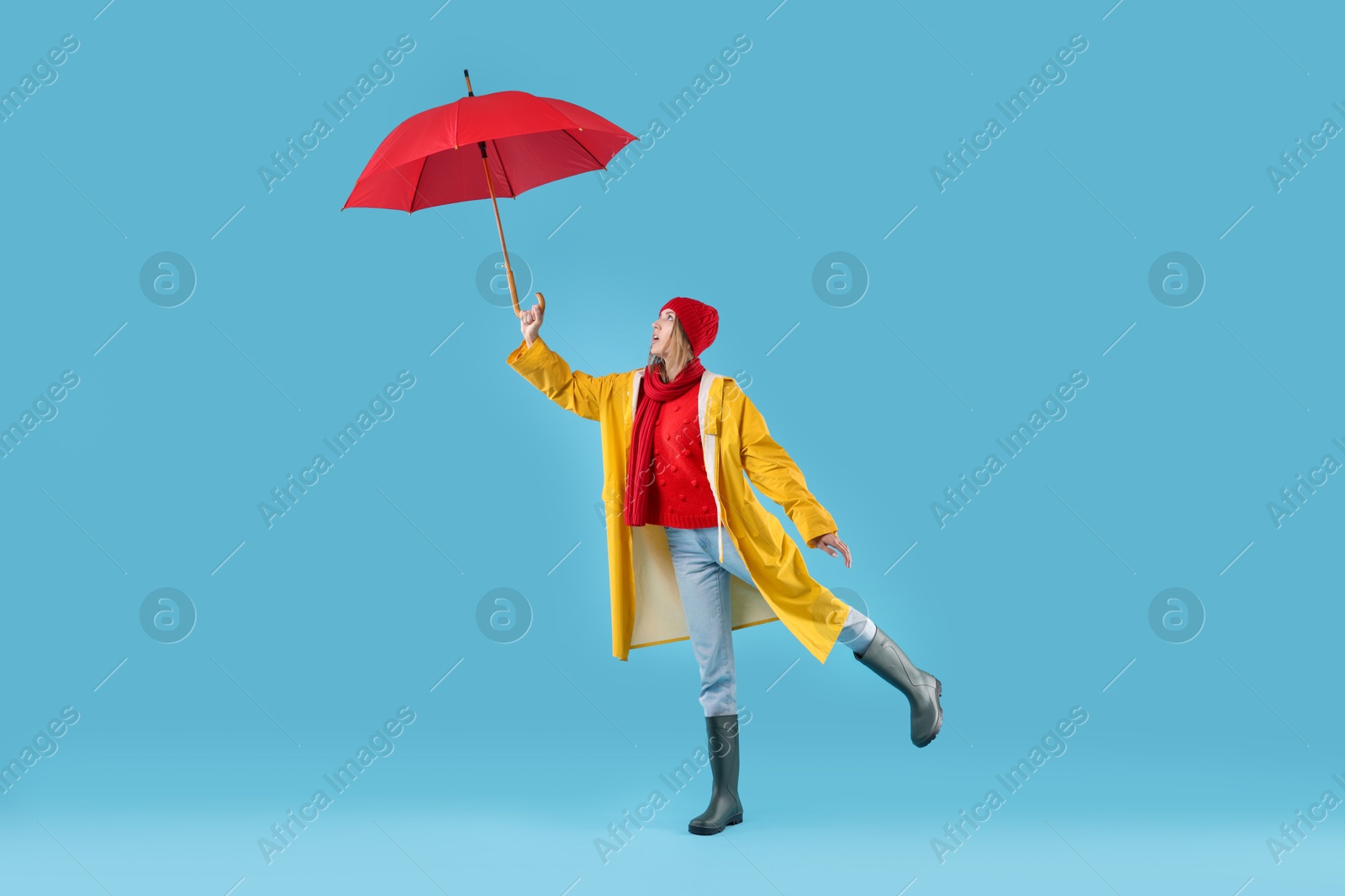 Photo of Woman with red umbrella on light blue background