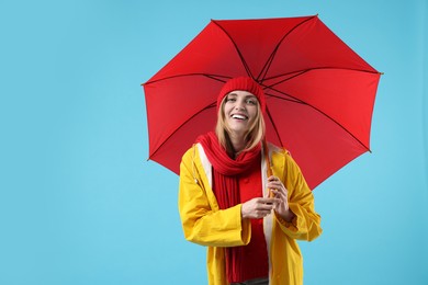 Photo of Woman with red umbrella on light blue background, space for text