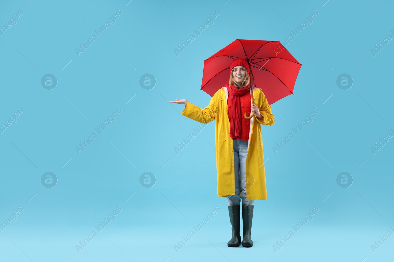 Photo of Woman with red umbrella on light blue background, space for text