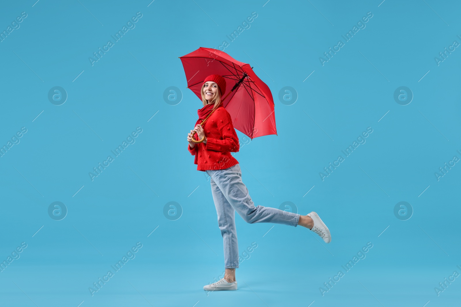 Photo of Woman with red umbrella on light blue background