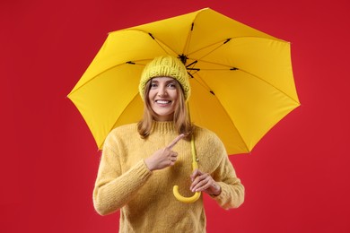 Woman with yellow umbrella on red background