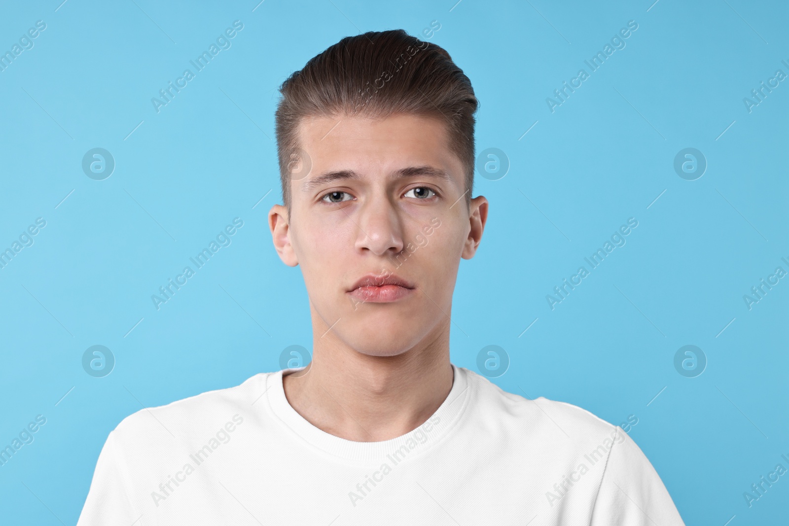 Photo of Portrait of handsome young man on light blue background