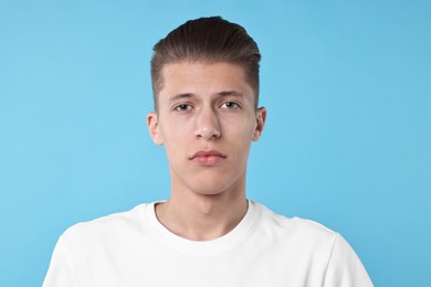 Portrait of handsome young man on light blue background