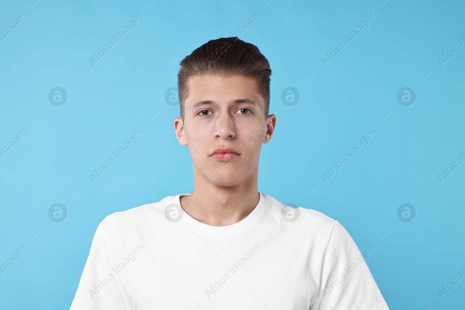 Photo of Portrait of handsome young man on light blue background